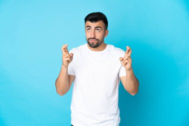 İzole edilmiş mavi arka planı olan beyaz bir adam, şans diliyor ve en iyisini diliyor.