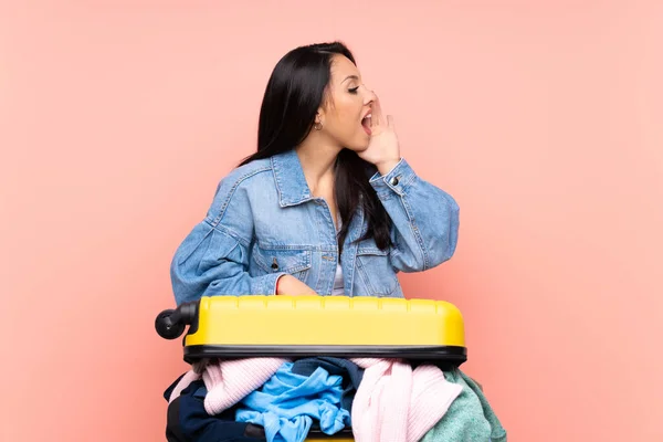 Utazó Kolumbiai Lány Egy Bőrönd Tele Ruhákkal Elszigetelt Rózsaszín Háttér — Stock Fotó