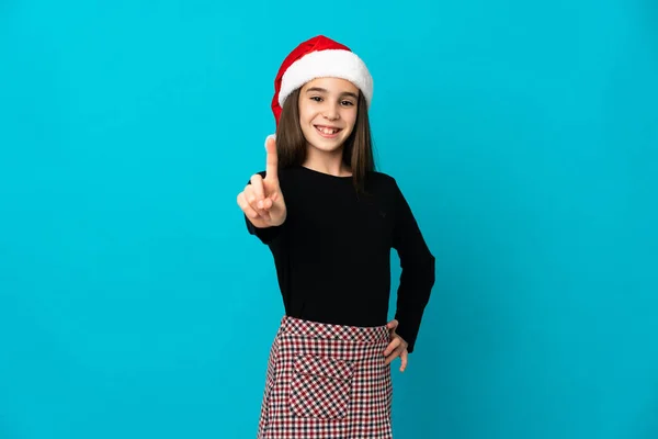 Niña Con Sombrero Navidad Aislado Sobre Fondo Azul Mostrando Levantando —  Fotos de Stock