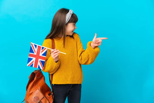 Mała Dziewczynka Studiuje Angielski Odizolowany Niebieskim Tle Wskazując Palcem Bok — Zdjęcie stockowe