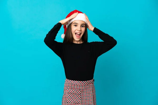 Κοριτσάκι Χριστουγεννιάτικο Καπέλο Απομονωμένο Μπλε Φόντο Έκφραση Έκπληξη — Φωτογραφία Αρχείου