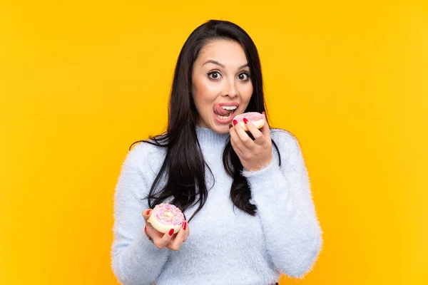 Junge Kolumbianische Mädchen Über Isolierten Gelben Hintergrund Hält Einen Donut — Stockfoto