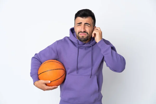 Człowiek Gra Koszykówkę Nad Odizolowaną Białą Ścianą Sfrustrowany Zakrywa Uszy — Zdjęcie stockowe