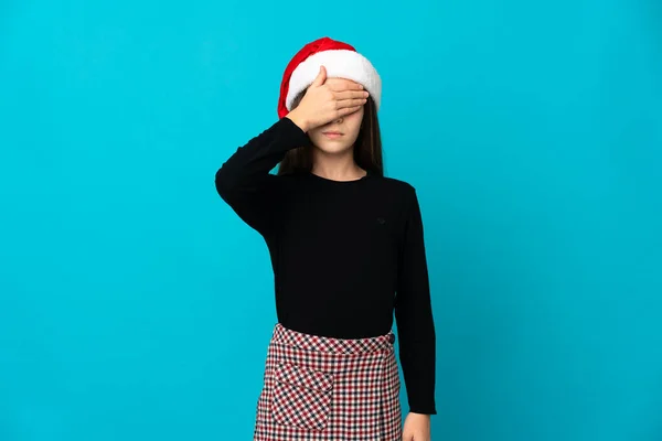 Liten Flicka Med Julen Hatt Isolerad Blå Bakgrund Täcker Ögon — Stockfoto