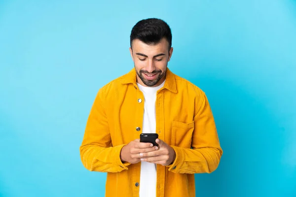 Zole Edilmiş Mavi Arkaplan Üzerinde Beyaz Adam Cep Telefonuyla Bir — Stok fotoğraf
