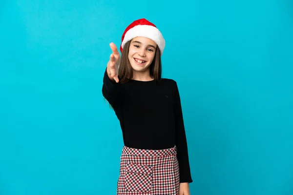 小女孩戴着圣诞礼帽 双手插在蓝色背景上 紧紧地握紧了手 好不容易才合上了 — 图库照片