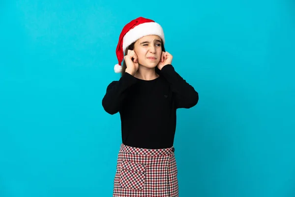 Маленькая Девочка Рождественской Шляпе Изолированы Синем Фоне Разочарование Покрытие Ушей — стоковое фото