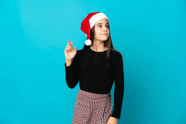 Menina Com Chapéu Natal Isolado Fundo Azul Com Dedos Cruzando — Fotografia de Stock