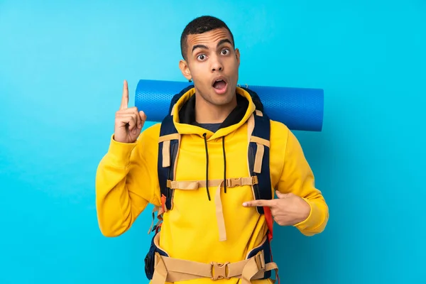 Junger Bergsteiger Mit Großem Rucksack Über Isoliertem Blauem Hintergrund Mit — Stockfoto