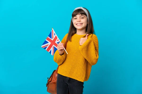 Little girl studying English isolated on blue background giving a thumbs up gesture