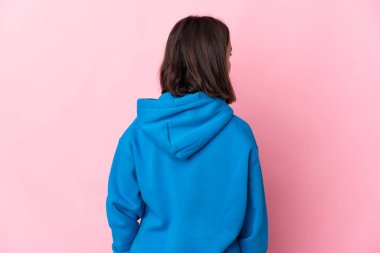 Arka planda pembe arka planda izole edilmiş genç Latin bir kadın var.