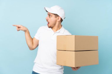Teslimat yapan beyaz adam mavi arka planda izole edildi.