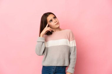 Little girl isolated on pink background making the gesture of madness putting finger on the head