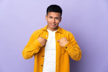 Genç Ekvadorlu, mor arka planda izole edilmiş, şaşırmış bir yüz ifadesi var.