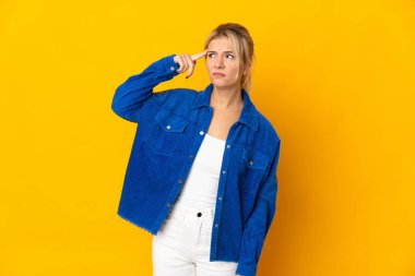 Young Russian woman isolated on yellow background making the gesture of madness putting finger on the head