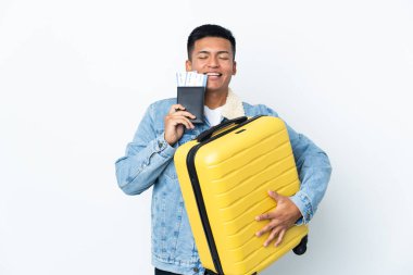 Genç Ekvadorlu adam beyaz arka planda izole edilmiş, bavul ve pasaportla tatilde.