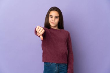 Mor arka planda izole edilmiş küçük kız başparmağın olumsuz ifadesini gösteriyor.