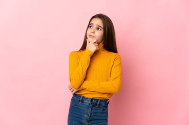 Pembe arka planda izole edilmiş küçük kızın şüpheleri var.