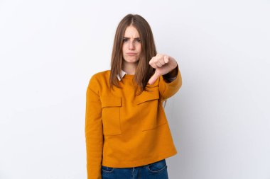 Izole beyaz arka plan üzerinde genç kadın olumsuz ifade ile başparmak aşağı gösteren