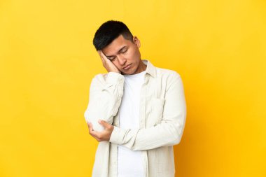 Genç Ekvadorlu adam sarı arka planda izole edilmiş baş ağrısıyla