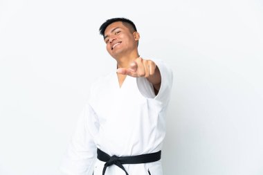 Beyaz arka planda karate yapan genç Ekvadorlu adam mutlu bir ifadeyle öne bakıyor.