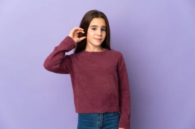 Mor arka planda kuşkuları olan küçük bir kız.