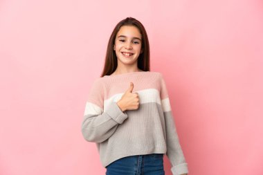Pembe arka planda izole edilmiş küçük bir kız baş parmak işareti yapıyor.