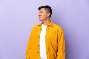 Genç Ekvadorlu adam mor arka planda izole edilmiş.