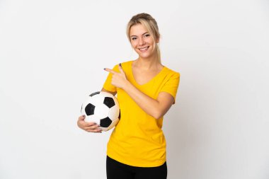 Young Russian woman isolated on white background with soccer ball and pointing to the lateral