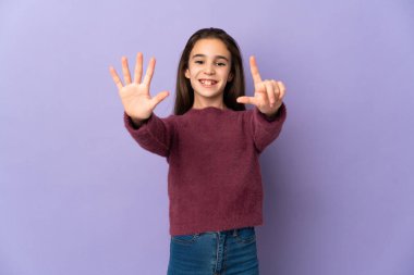 Little girl isolated on purple background counting seven with fingers