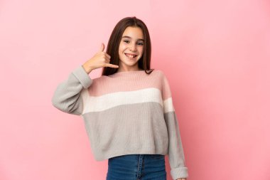 Pembe arka planda izole edilmiş küçük bir kız telefon jesti yapıyor. Bana geri dönüş işareti ver.