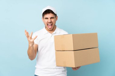 Delivery caucasian man isolated on blue background unhappy and frustrated with something