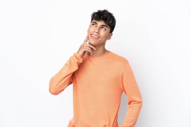 Young man over isolated white background thinking an idea while looking up