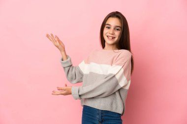 Pembe arka planda soyutlanmış küçük bir kız. Davet edilmek için ellerini yana uzatıyor.