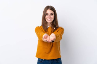 İzole edilmiş beyaz arka plan üzerinde genç bir kadın bir ilan vermek için avucunun içinde hayali bir alan tutuyor.