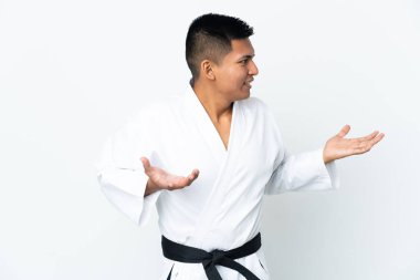 Genç Ekvadorlu adam beyaz arka planda karate yapıyor.