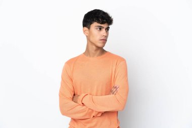 Young man over isolated white background keeping the arms crossed