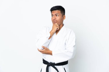 Beyaz arka planda karate yapan genç Ekvadorlu adamın şüpheleri ve düşünceleri var.