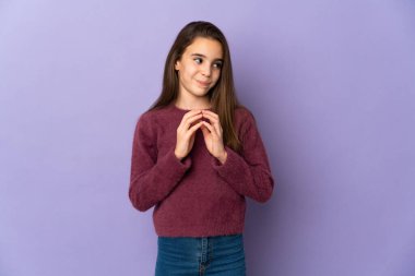 Mor arka planda izole edilmiş küçük kız bir şeyler planlıyor.