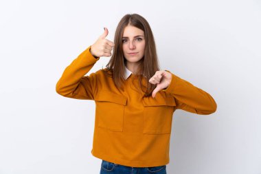 Genç kadın, izole beyaz arka planda iyi-kötü işaret yapıyor. Evet ya da değil arasında kararsız