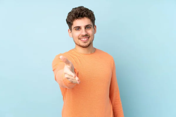 Blanke Man Geïsoleerd Blauwe Achtergrond Schudden Handen Voor Het Sluiten — Stockfoto