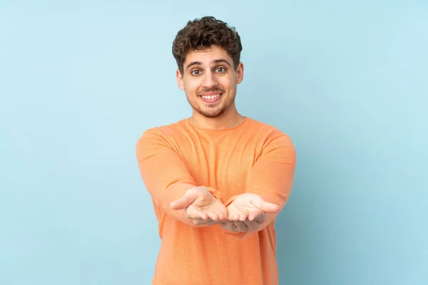 Homem Caucasiano Isolado Fundo Azul Segurando Copyspace Imaginário Palma Mão — Fotografia de Stock