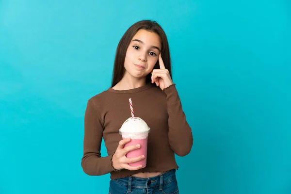イチゴミルクセーキを持つ女の子は青の背景に隔離された考え方 — ストック写真