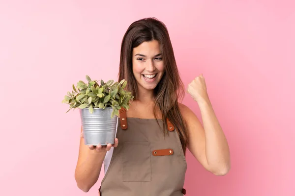 Menina Jardineiro Adolescente Segurando Uma Planta Sobre Fundo Rosa Isolado — Fotografia de Stock