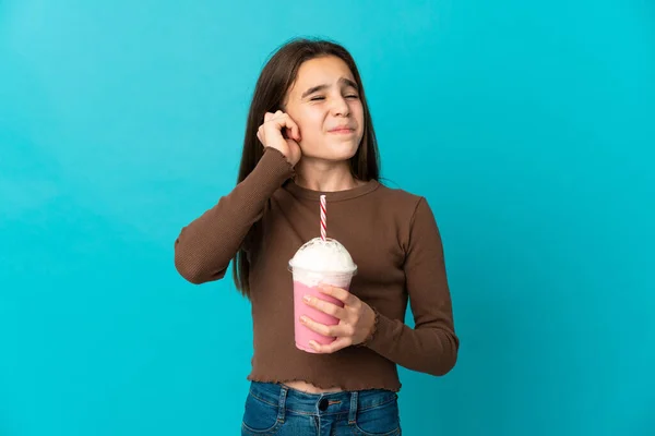 小さな女の子とともにストロベリーミルクセーキ隔離上の青背景不満とカバー耳 — ストック写真