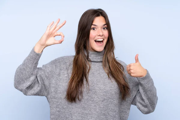 Teenager Brasilianische Mädchen Über Isolierten Blauen Hintergrund Zeigt Zeichen Und — Stockfoto