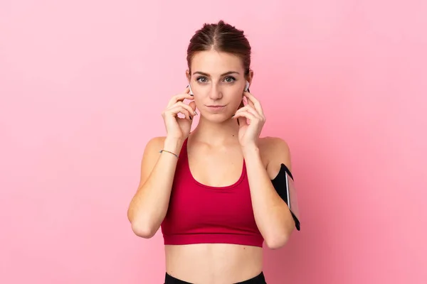 Jonge Sport Vrouw Geïsoleerde Roze Achtergrond Luisteren Muziek Kijken Naar — Stockfoto
