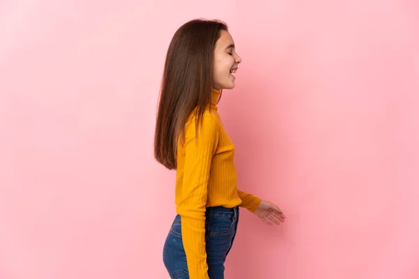 Klein Meisje Geïsoleerd Roze Achtergrond Lachen Laterale Positie — Stockfoto