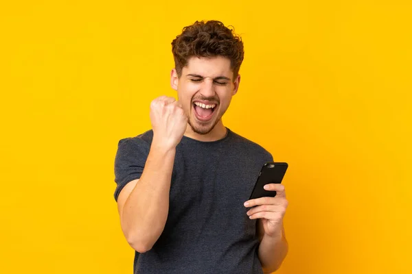 Young Caucasian Man Isolated Background Phone Victory Position — Stock Photo, Image