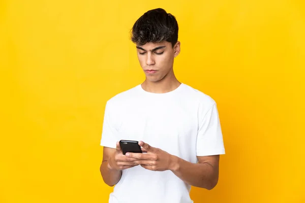 Young Man Isolated Yellow Background Using Mobile Phone — Stok fotoğraf